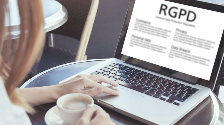 chica tomando café y revisando información en portátil